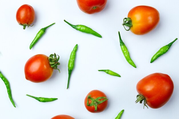 Composition of fresh green chili with tomato isolated on white background