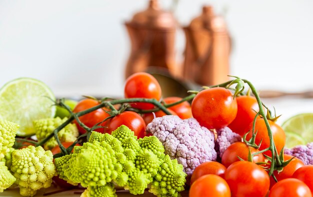 Composition of fresh vegetables pans and cutlery on white background