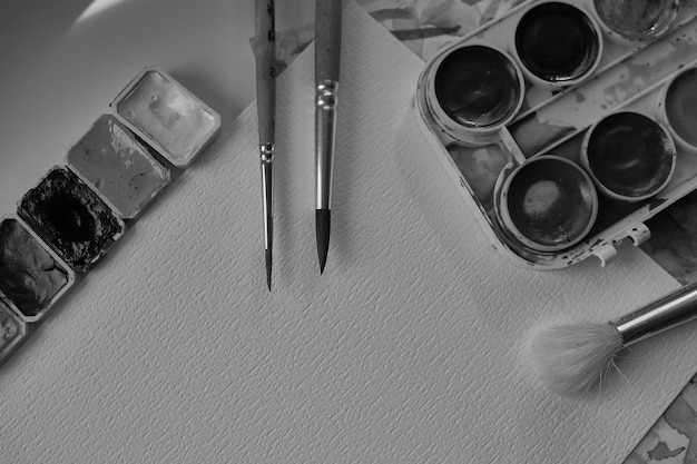 composition from art materials watercolor paints multicolored paintsblack and white photo