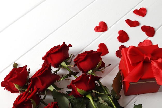 composition from a bouquet of beautiful red roses, gift box on the background. valentine's day gift.
