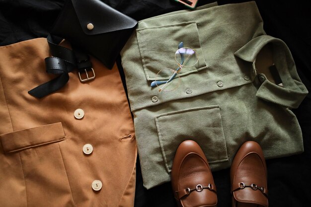 Photo composition from clothes shirts and a jacket with loafers on a dark background clothing