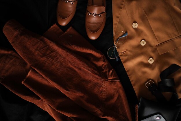 Composition from clothes Shirts and a jacket with loafers on a dark background Clothing