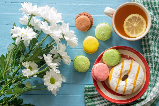 Composition good morning cake and tea flowers on a blue wooden background top view