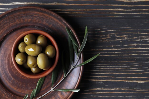 Composizione di olive verdi, olio d'oliva, marinata su fondo di legno da vicino