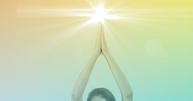 Photo composition of hands of woman practicing yoga with glowing light and yellow to green tint