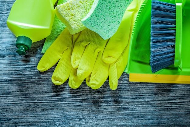 Composition of household cleaning tools on vintage wooden board