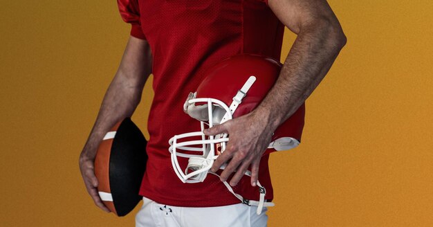 Composition of male american football player holding ball on red background