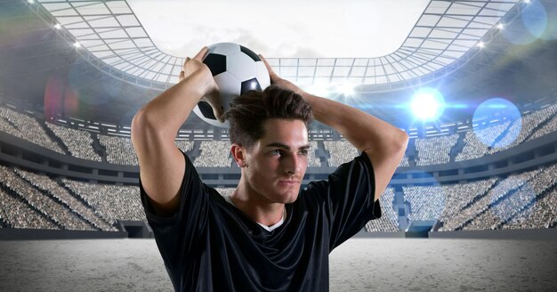 Composition of male football player holding football over sports stadium