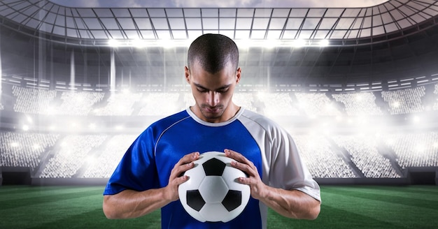 Composition of male football player holding football over sports stadium