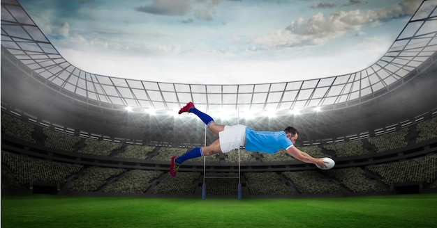 Composition of male rugby player diving holding ball on rugby pitch