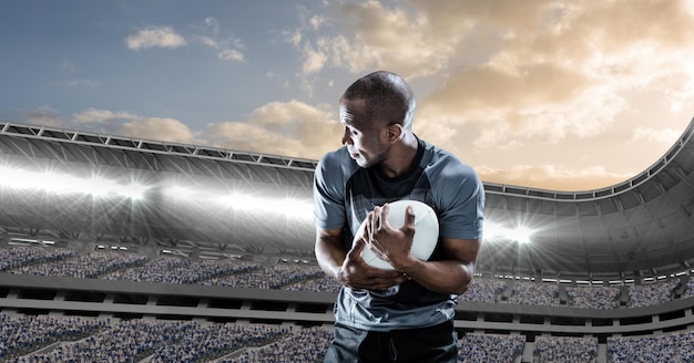 Composition of male rugby player holding rugby ball over sports stadium