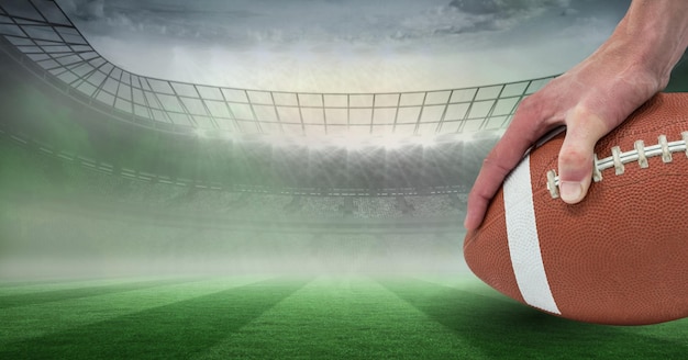 Composition of male rugby player holding rugby ball over sports stadium