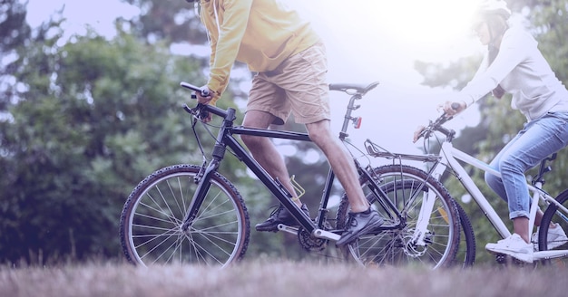 Composition of man and woman riding bikes in countryside