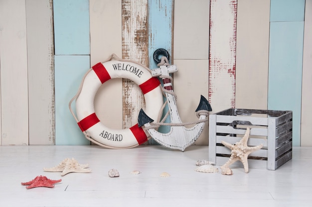 Photo composition on a marine theme with an anchor and life buoy, seashells and starfish