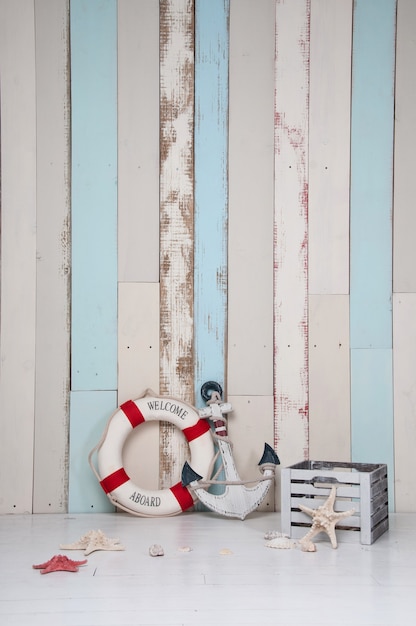 Photo composition on a marine theme with an anchor and life buoy, seashells and starfish