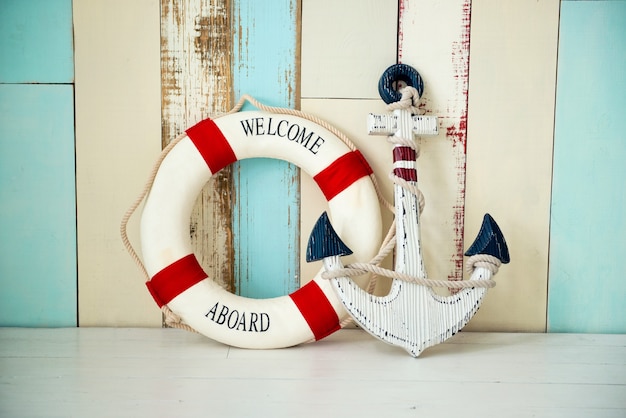 Photo composition on the marine theme with anchor and lifeline on wooden background.