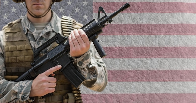 Composition of midsection of male soldier holding gun, against american flag