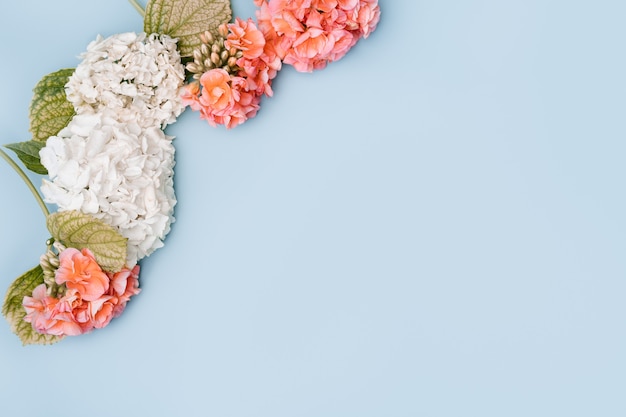 Composition of mixed flowers on blue background. top view, copy space.