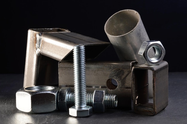 Composition of nuts bolts and scraps of metal laid out on a dark backgroundxA