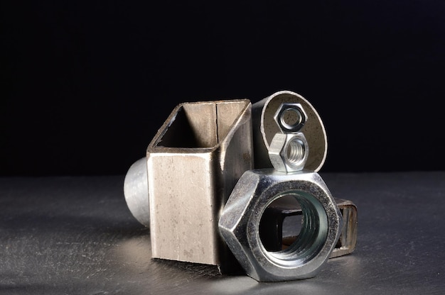 Composition of nuts bolts and scraps of metal laid out on a dark backgroundxA