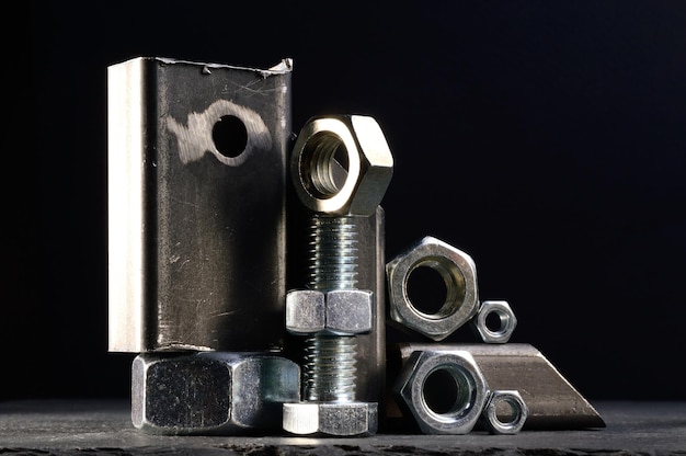 Composition of nuts bolts and scraps of metal laid out on a dark backgroundxA