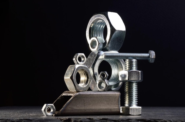 Composition of nuts bolts and scraps of metal laid out on a dark backgroundxA