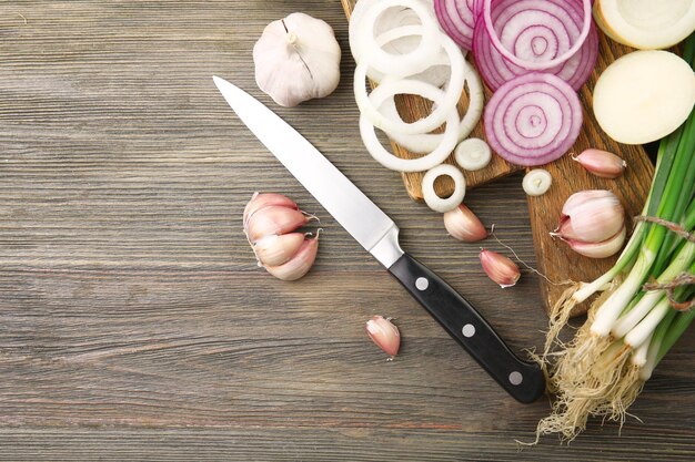 Composition of onions and garlic on wooden background