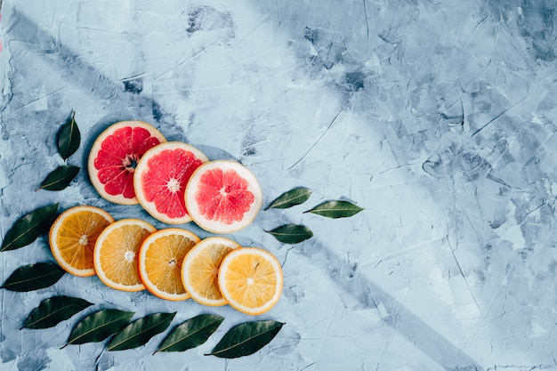 Composition of orange slices and grapefruit on a gray table top view