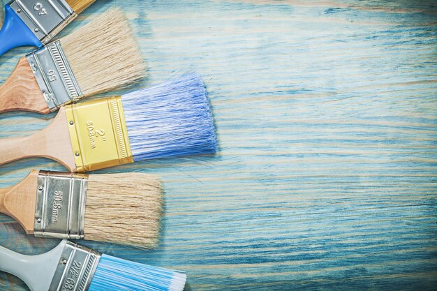 Composition of paint brushes on wood board construction concept
