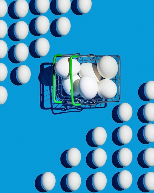 Photo composition of a pattern of white eggs on a blue background and a basket with eggs