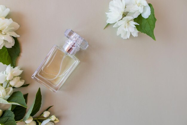 Composition of a perfume bottle with a floral delicate aromat and white jasmine flowers on a gray background top view a copy of the space