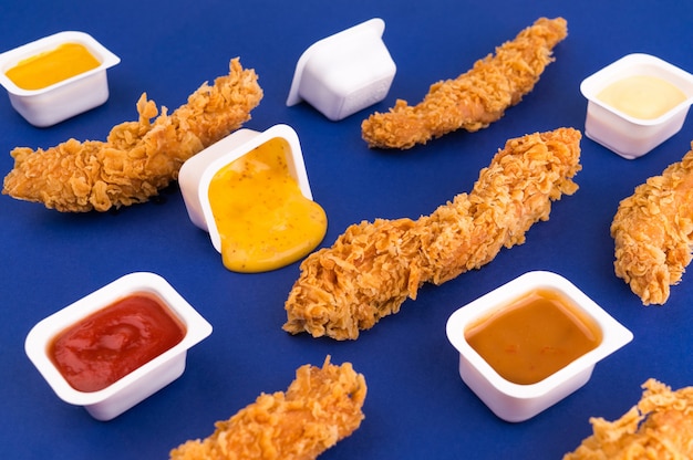 Composition of pieces of chicken, packaging of ketchup and\
sauces