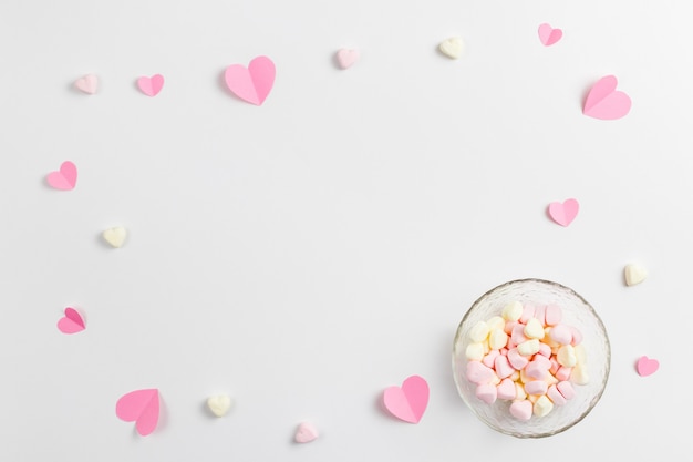 Photo composition of pink hearts made of paper and heart-shaped marshmallows