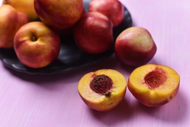 Composition of ripe peaches on a pink background