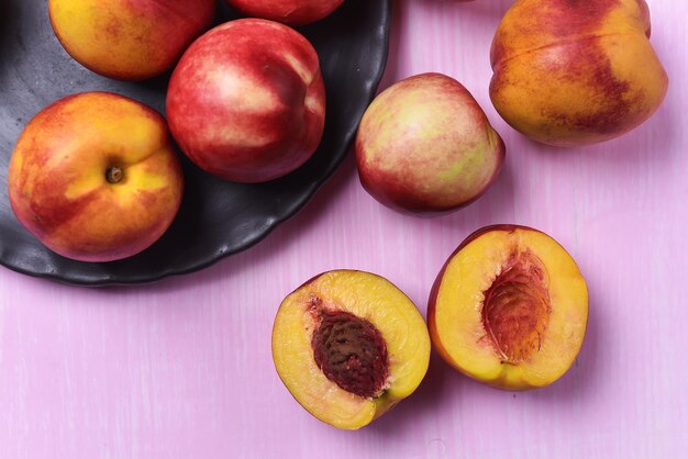 Composition of ripe peaches on a pink background