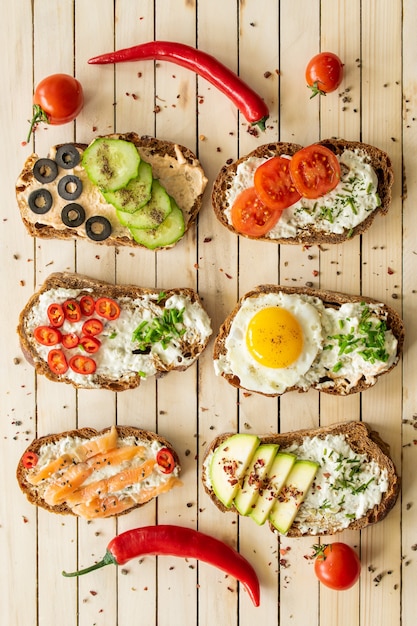 Composition sandwiches with vegetables salmon and egg on a wooden background proper nutrition