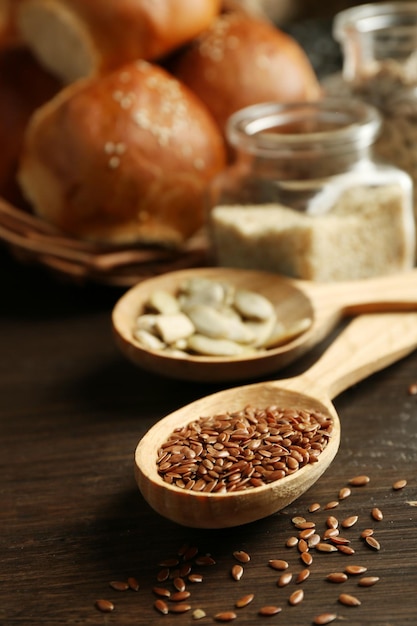 Composition of seeds and buns on wooden table background closeup