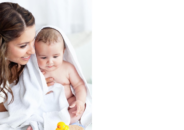 Composition of smiling mother holding baby wrapped in blanket