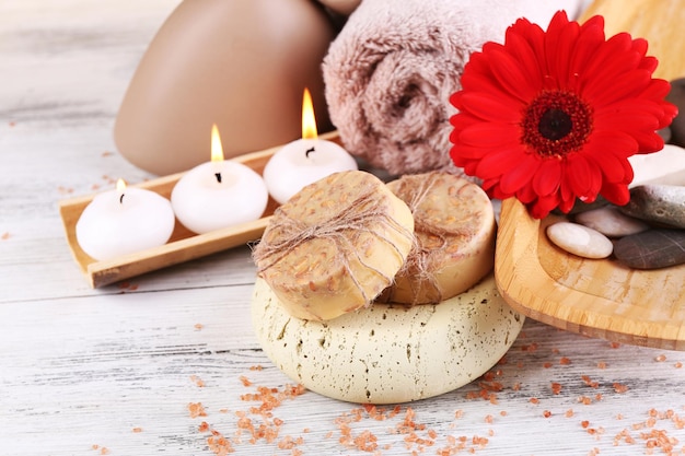 Composition of spa stones sea salt and massage bags on wooden table on light color background