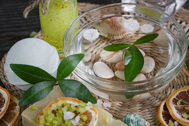 Composition of spa treatment with green salt and soap on wooden surface