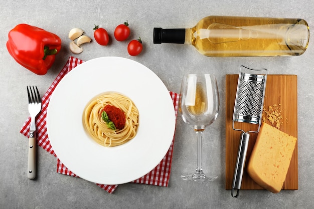 Состав спагетти в белой тарелке на сером фоне