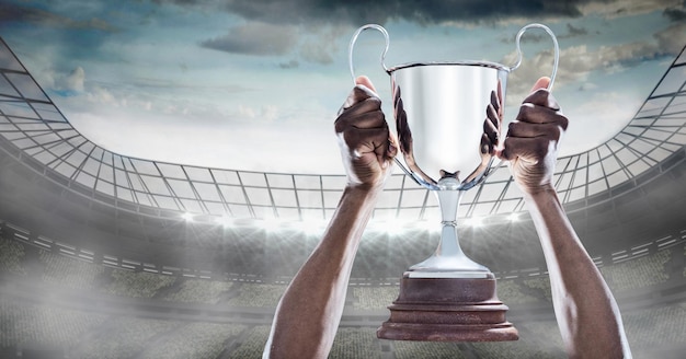 Composition of sportsman celebrating victory, holding trophy at stadium