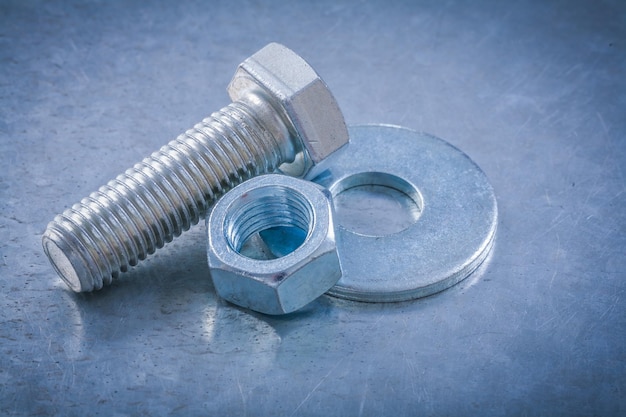 Composition of stainless bolt washer screwbolt screwnut on metallic background