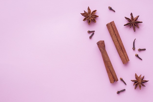 Composition of star anise, cinnamon sticks and cloves, top view background with copyspace