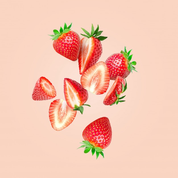 The composition of strawberries. Cut strawberries into pieces flying in the air