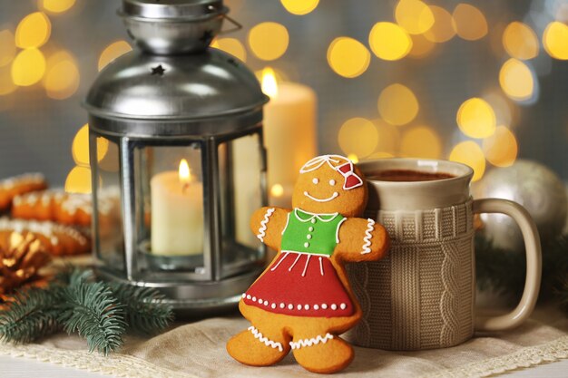 Composition of tasty gingerbread cookie, mug and Christmas decor