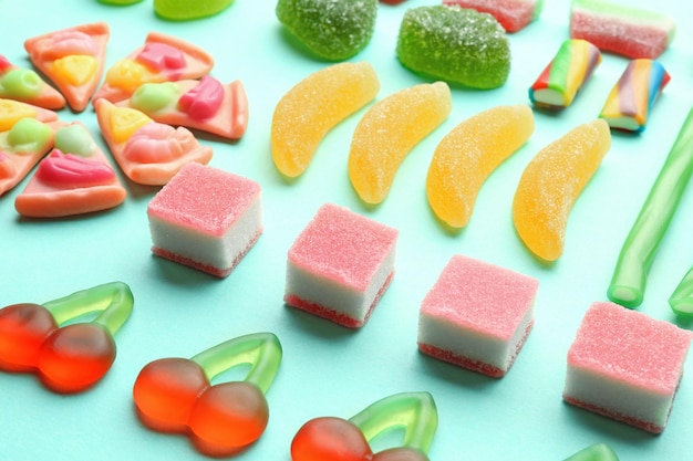 Composition of tasty jelly candies on color background closeup