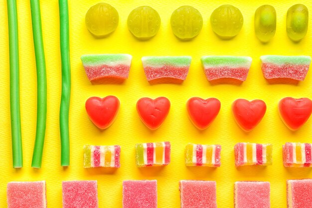 Photo composition of tasty jelly candies on color background