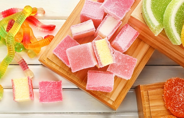 Composition of tasty jelly candies on wooden background