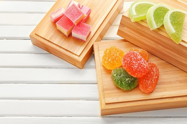 Composition of tasty jelly candies on wooden background